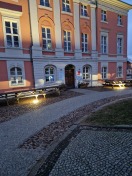 Foto: Holzbänke vor den Bodenstrahlern des historischen Rathauses  