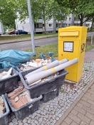 Foto: Bauschutt vor dem Briefkasten der Post 
