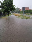Foto: Überlaufende Gullis & Wasseransammlung auf öffentlicher Straße. 