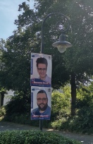 Foto: Wahlplakate an lackierten, schmalen Laternenpfählen 