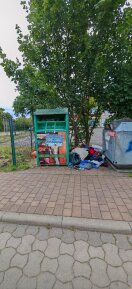 Foto: Kleiderspender Übervoll - Kleiderspenden daneben in Mengen 