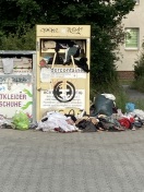 Foto: Berge von alter Kleidung VOR dem Container 