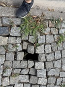 Foto: Unterspülung der Pflastersteine inkl. Loch im Gehweg 